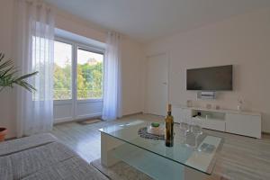 un salon avec une table en verre et une télévision dans l'établissement Guesthouse L&K SPA, à Brinje