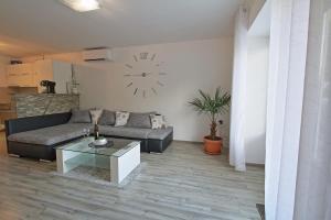 - un salon avec un canapé et un réveil sur le mur dans l'établissement Guesthouse L&K SPA, à Brinje