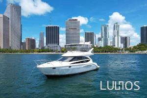 a white boat in the water in front of a city at Elegant1BR Apartment with Stunning Renovations in Miami L08A in Tamiami