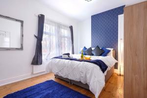 a bedroom with a bed with a blue wall at 3 Bedroom House in City Centre - Sleeps up to 7 - Free Parking, Fast Wifi, Pool Table and SmartTV with SkyTV and Netflix by Yoko Property in Northampton