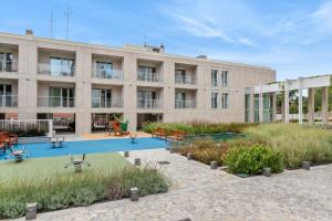 an apartment building with a pool in front of it at Limehome Milan via Stresa in Milan
