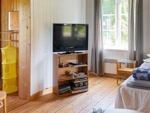 uma sala de estar com televisão num suporte de madeira em Holiday home TORPSHAMMAR em Torpshammar