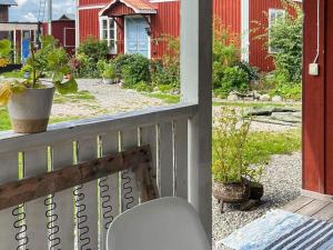 a porch with a chair and a yard with houses at Holiday home TORPSHAMMAR in Torpshammar