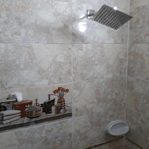 a bathroom with a shower with a tiled wall at Nana Pyramids Guest House in Cairo +65 photos