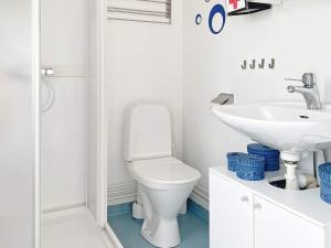 Baño blanco con aseo y lavamanos en Holiday home Mönsterås VIII en Mönsterås
