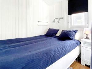 1 cama con sábanas azules en una habitación blanca en Holiday home Mönsterås VIII en Mönsterås