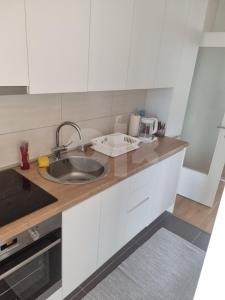 a kitchen with white cabinets and a sink at Luxury apartment Sunny place in Mostar