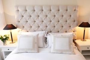 a bedroom with a large white bed with two lamps at Belgravia flat, with private Terrace in London