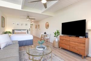 a living room with a flat screen tv and a couch at Kihei Bay Surf 140 in Kihei