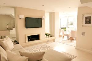 a living room with a fireplace and a tv on a wall at Belgravia flat, with private Terrace in London