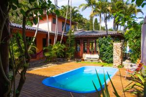 una casa con piscina frente a una casa en Pousada Paradise Ferrugem, en Garopaba