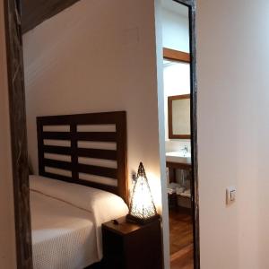 a bedroom with a bed and a mirror and a lamp at Hotel Makasa in Mogente