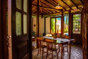 a dining room with a table and chairs in a house at Pousada Paradise Ferrugem in Garopaba