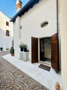 an open door of a white building with plants at Ca' Degli Uberti Dimora Storica in Treviso