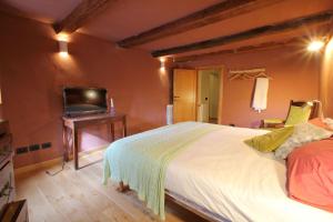 - une chambre avec un lit et une télévision sur une table dans l'établissement Castelletto, à Giucano