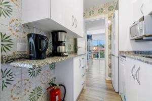 a kitchen with white cabinets and a counter top at Apartamento Paul in Torredembarra