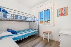 a bedroom with two bunk beds and a window at Apartamento Paul in Torredembarra