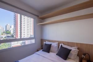 a bedroom with a bed and a large window at 360 Ascent Paulista in Sao Paulo