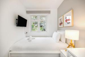 a white bedroom with a bed and a window at The Rectory Retreat in London