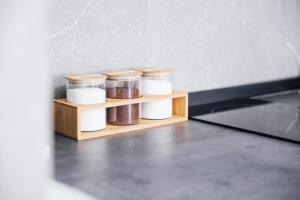 a spice rack with four jars on a wooden shelf at Valletta Waterfront 2 Beds Flat in Il-Furjana