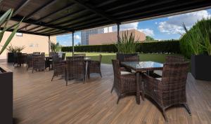 a patio with tables and chairs on a deck at Courtyard by Marriott San Luis Potosi in San Luis Potosí