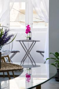 a glass table with flowers on it in a room at Valletta Waterfront 2 Beds Flat in Il-Furjana