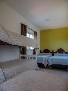 1 dormitorio con 2 camas, sofá y ventana en Departamentos Daniotti en Villa del Totoral