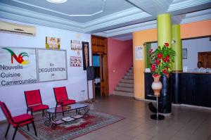 a lobby with two red chairs and a table at SUP HOTEL in Douala