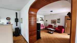 a living room with a wooden door and red chairs at Casolare Nanis in Travesio