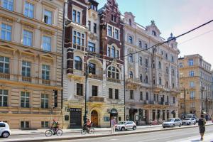 people riding bikes on a city street with buildings at Art House Apartments by Adrez in Prague