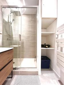 une salle de bain avec une douche avec une porte vitrée dans l'établissement Appartement T2 Village Oletta, à Oletta