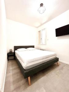 une chambre avec un grand lit dans une pièce dans l'établissement Appartement T2 Village Oletta, à Oletta