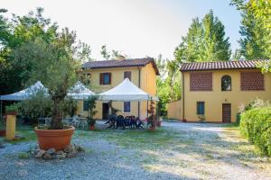 une grande maison jaune avec une tente dans la cour dans l'établissement Camping dei Tigli, à Torre del Lago Puccini