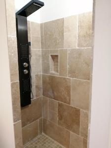 a shower with a glass door with a brown tile shower at Les chalets de Palavesa in Porto-Vecchio +21 photos
