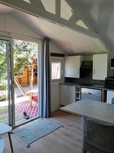 eine Küche mit einer offenen Tür zu einer Terrasse in der Unterkunft Les chalets de Palavesa in Porto-Vecchio
