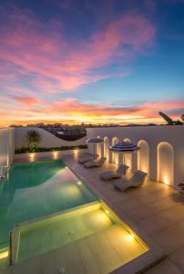 a villa with a swimming pool and a sunset at Sleep Whale Hotel in Krabi town