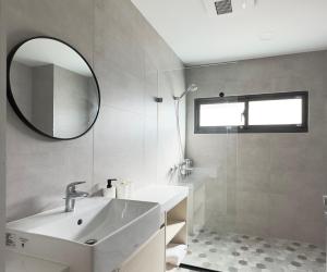 a bathroom with a sink and a mirror and a shower at W Q Villa in Yilan City