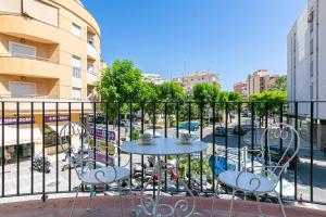 uma mesa e cadeiras numa varanda com uma rua em Central Torremolinos Apartment em Torremolinos