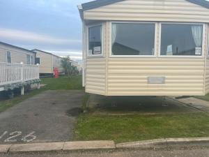 a mobile home is parked in a parking lot at 3 Bedroom Caravan - Maples 126, Trecco Bay in Newton