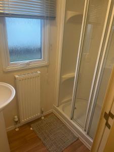 a bathroom with a shower and a sink at 3 Bedroom Caravan - Maples 126, Trecco Bay in Newton