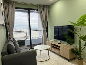 a living room with a couch and a large window at ImPian 1BR condo in Phnom Penh