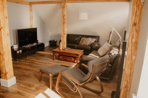 a living room with a couch and a tv at Vītola apartamenti in Kuldīga