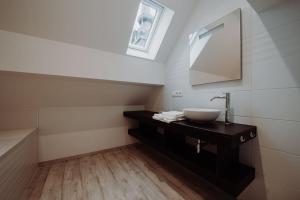 La salle de bains est pourvue d'un lavabo et d'un miroir. dans l'établissement Chimay : La Grande Réserve, à Chimay