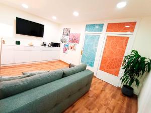 a living room with a couch and a flat screen tv at Next to Paseo de Gracia Rooms in Barcelona