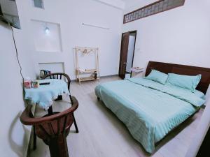 a bedroom with a bed and a table and a mirror at Nhà nghỉ Bonne Vie' Homestay in Can Tho