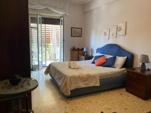 a bedroom with a bed with a blue head board at Mammo's House in Rome