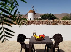 a table with a bowl of fruit and a windmill at Casita rural Molino de La Corte in Antigua