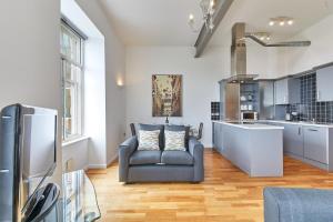 sala de estar con silla y cocina en The Loft - Properties Unique, en Newcastle