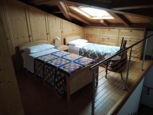 een kleine kamer met 2 bedden en een trap bij Ca' Pinetta in Rua di Feletto
