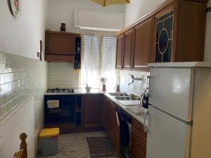 a kitchen with wooden cabinets and a white refrigerator at Mammo's House in Rome